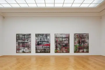 Ausstellungswand, an welcher sich vier Gemälde befinden