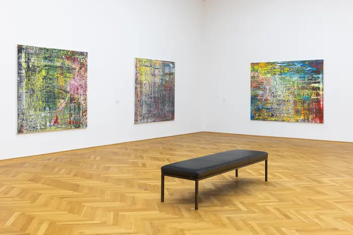 Ausstellungsansicht mit Blick auf Abstrakte Bilder und eine Bank
