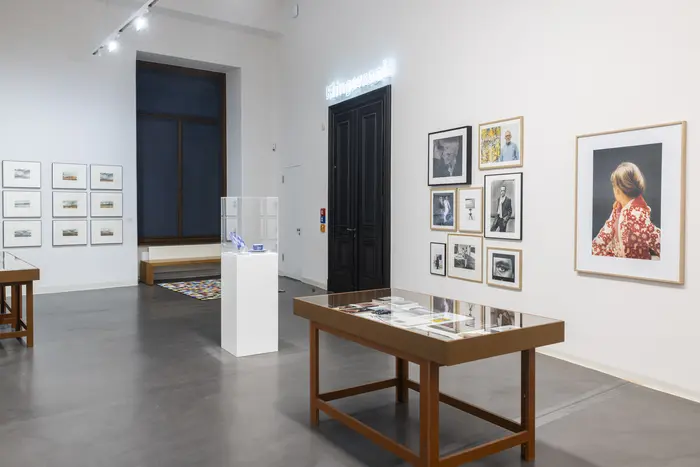 Raumansicht mit Vitrinen und unterschiedlich großen gerahmten Bildern