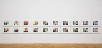 eine Wand mit vielen kleinen bunten Bildern an der Wand